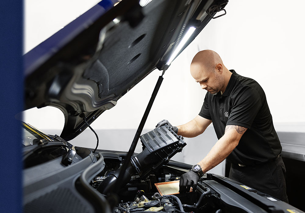 A man changing the cabin filter on a Volkswagen