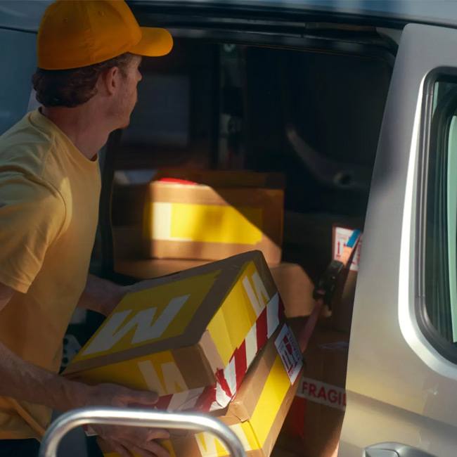 Man storing boxes in the rear of a panel van