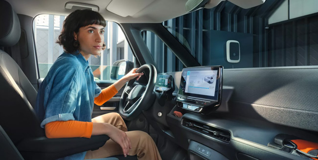 A woman in the drivers seat of an electric Volkswagen van
