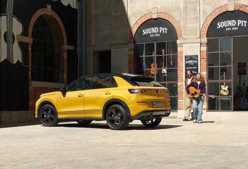 A Yellow Volkswagen SUV parked outside of a music shop