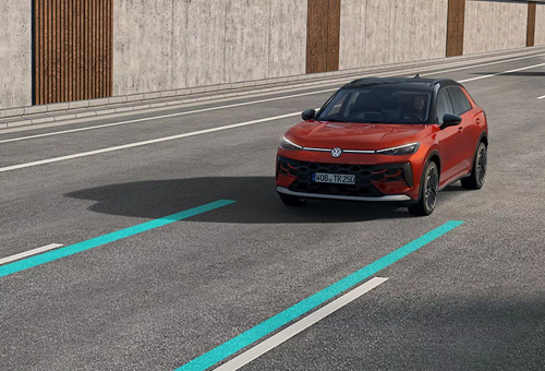 A red T-Roc driving on a highway with the lanes highlighted